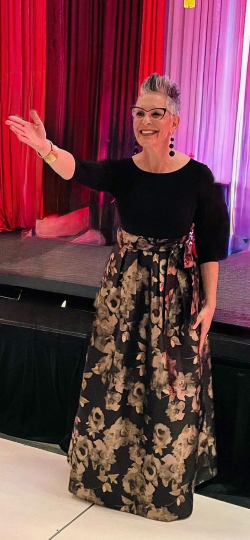 Debbie Scheer benefit auctioneer on stage at nonprofit gala Denver Colorado
