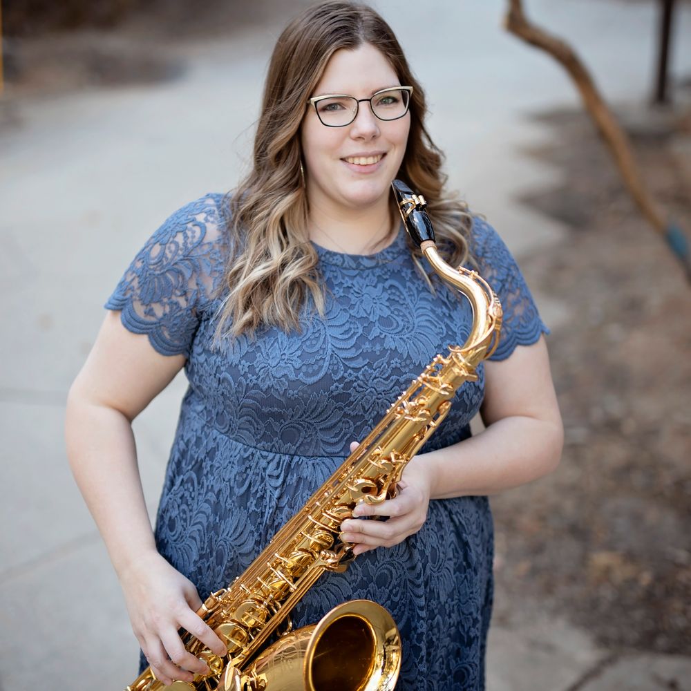 Saxophone teacher, Kayleigh Francis smiling and holding her saxophone